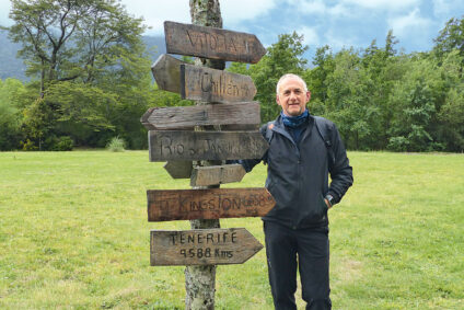 Detlev Kindermann beim Wandern an Wegweiserschildern.