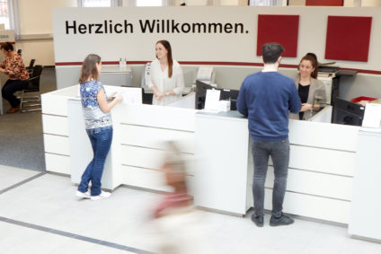 Mitarbeiter der BMW BKK bedienen am Empfangstresen Kunden.