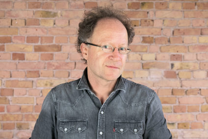 Dr. Martin Hirsch vor einer Ziegelwand.